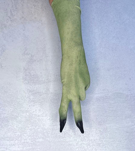 A single long green glove or sleeve worn on a hand, shown against a light textured background. The glove is olive green with two black-tipped fingers in an upside down peace sign. Palm down