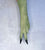 A single long green glove or sleeve worn on a hand, shown against a light textured background. The glove is olive green with two black-tipped fingers in an upside down peace sign. Palm down
