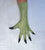 A single long green glove or sleeve worn on a hand, shown against a light textured background. The glove is olive green. Fingers spread wide.  Palm down